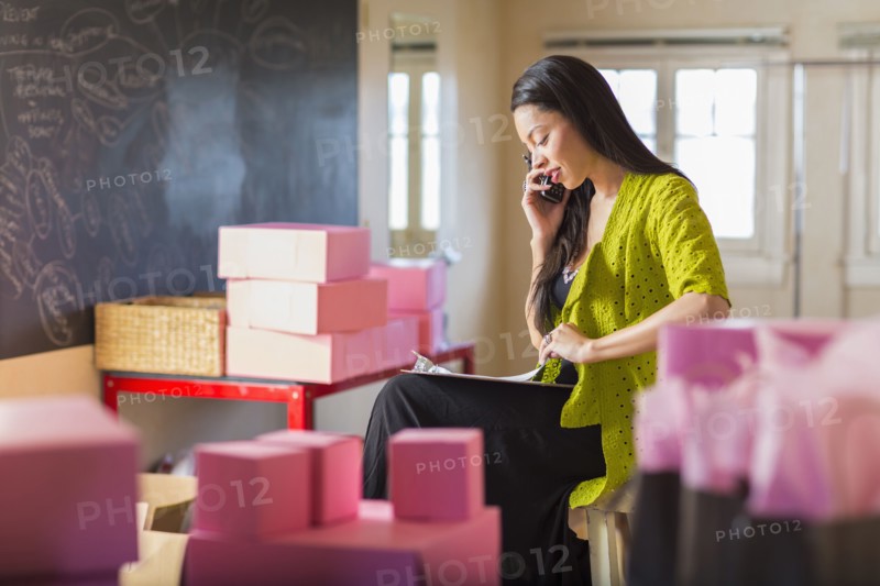 Mixed race businesswoman talking on telephone in office