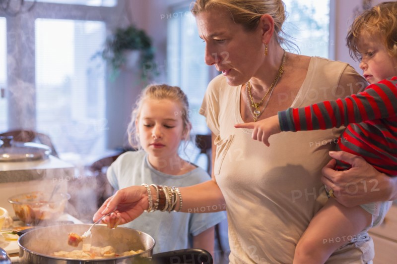 Caucasian mother and children cooking in kitchen