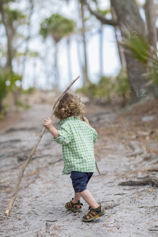 Caucasian baby boy walking on dirt path