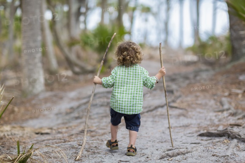 Caucasian baby boy walking on dirt path