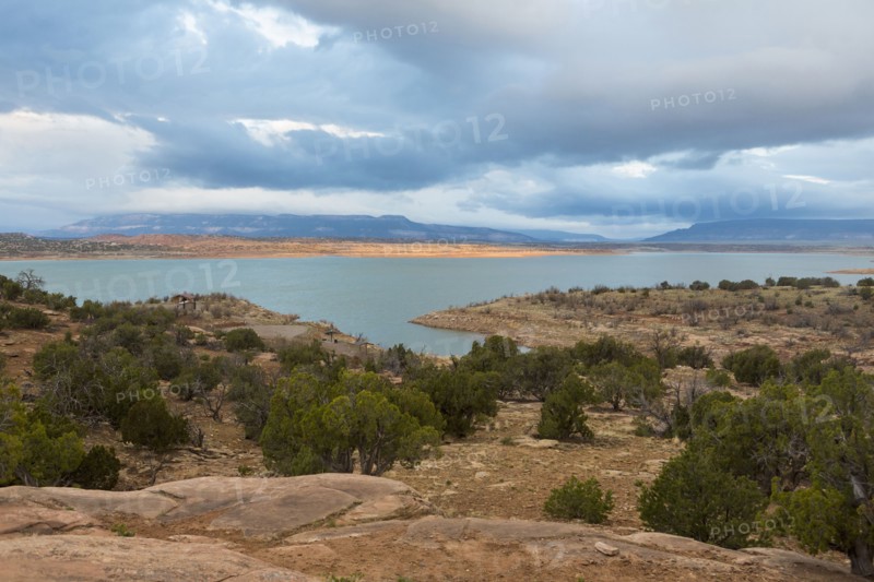 Desert landscape and river under cloudy sky