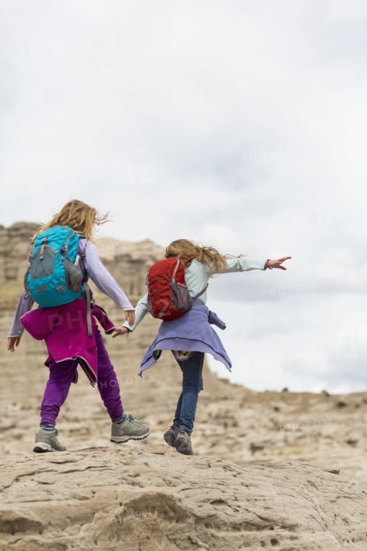 Caucasian girls exploring desert rock formations