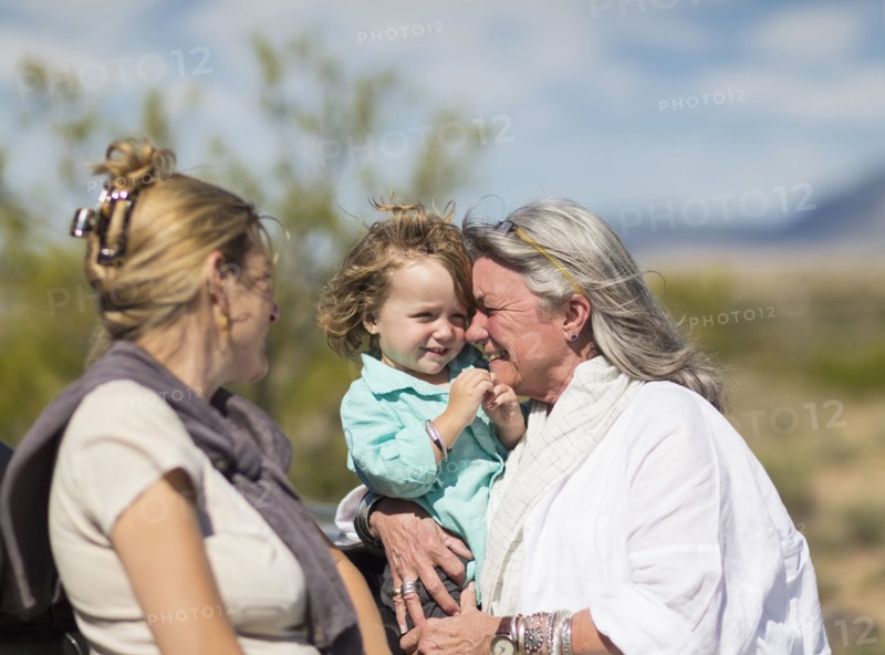Multi-generation Caucasian family hugging outdoors