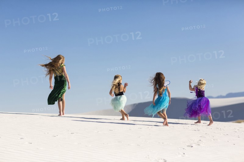 Girls walking on desert sand dunes