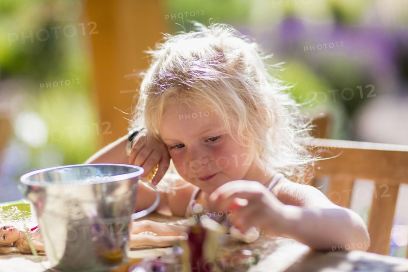 Caucasian girl playing with dolls at table