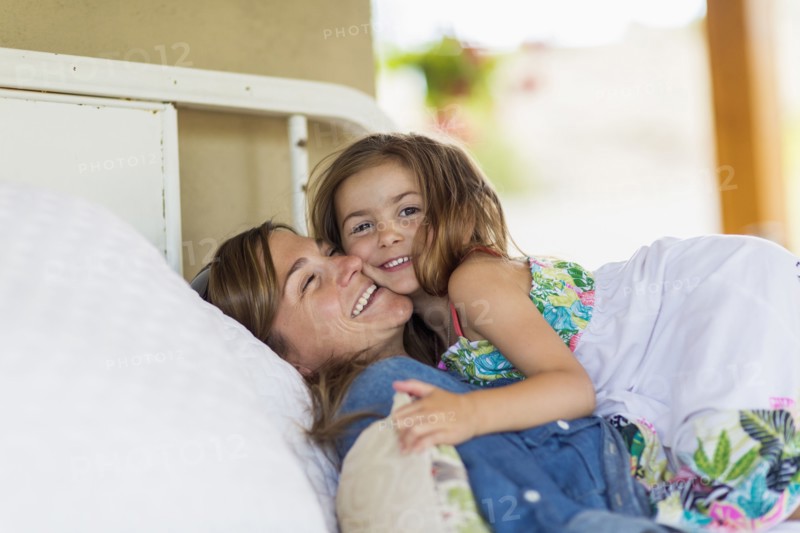 Mother and daughter hugging on bed