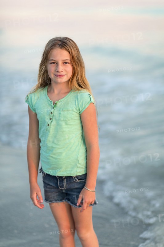 Caucasian girl standing in ocean waves