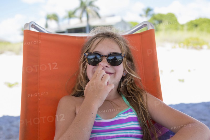 Caucasian girl picking nose on beach