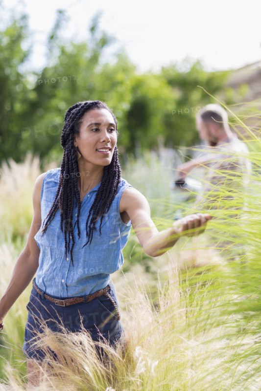 Woman examining tall plants in garden