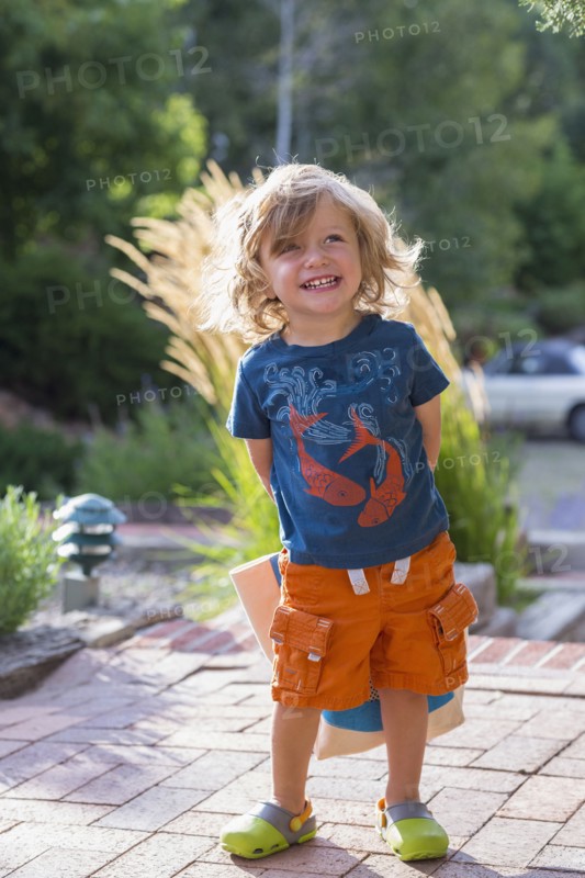 Caucasian toddler hiding gift behind back