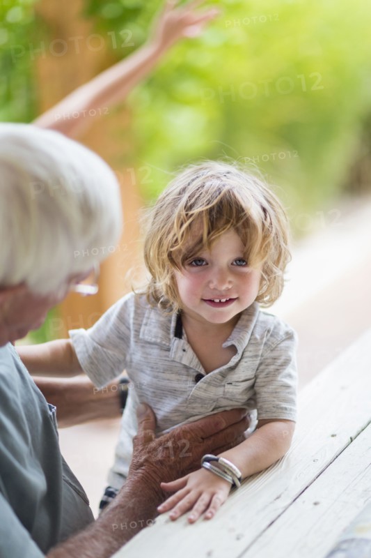 Caucasian grandfather and grandson sitting at table