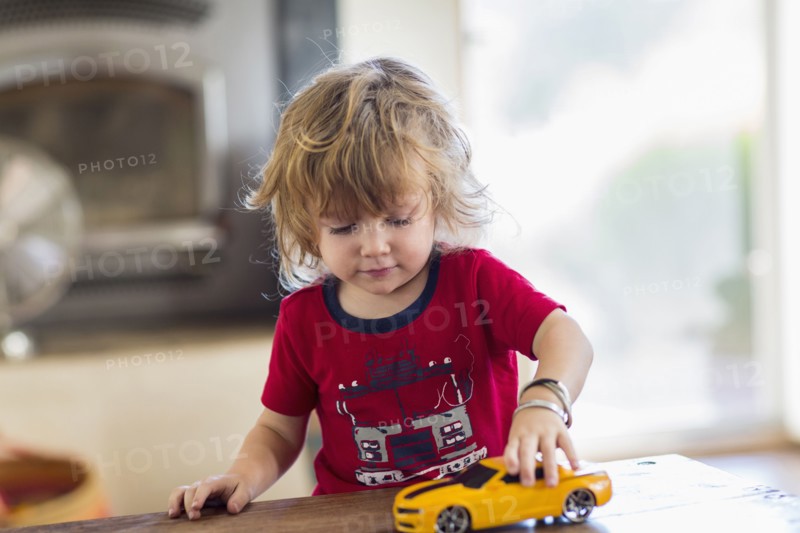 Caucasian boy playing with toy car