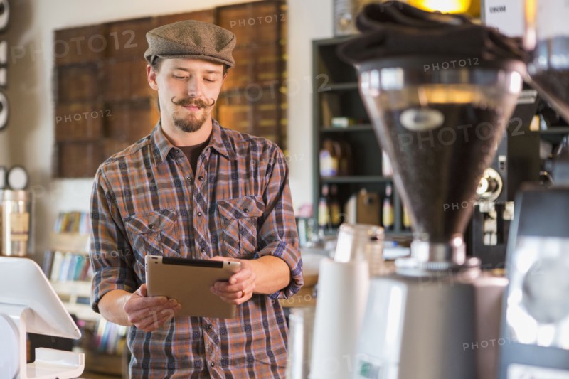 Caucasian man using digital tablet in cafe