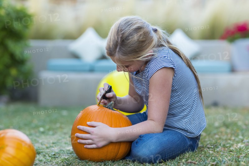 Caucasian girl carving pumpkin