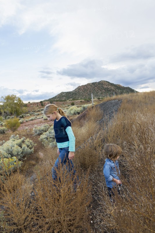 Caucasian children exploring hillside