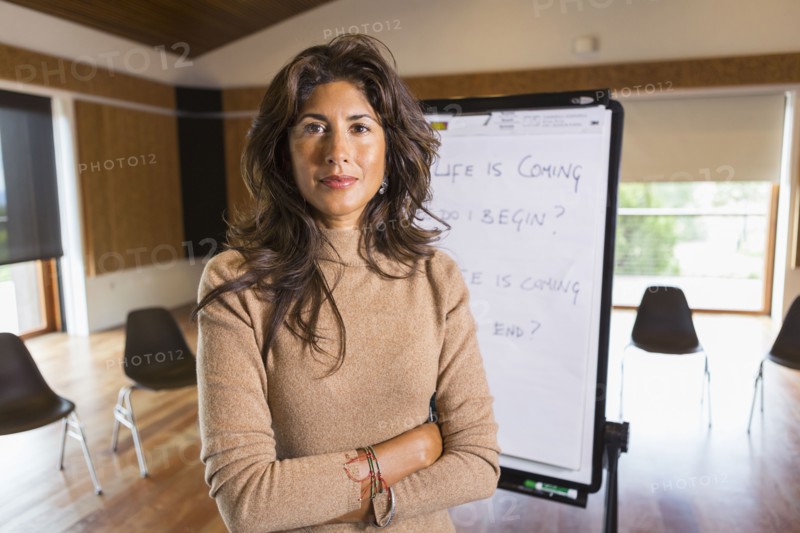 Hispanic businesswoman standing in meeting room