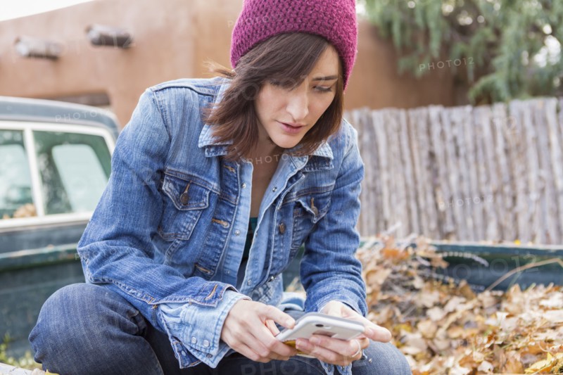 Hispanic woman using cell phone in truck bed