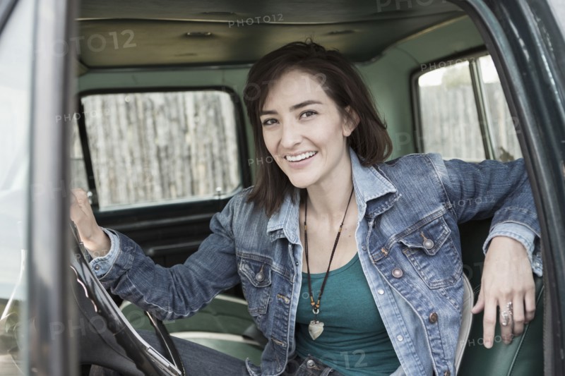 Hispanic woman sitting in truck
