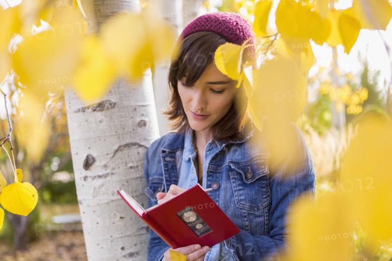 Hispanic woman writing in tree
