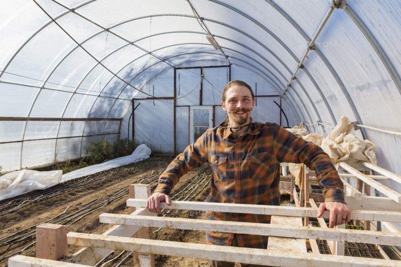 Caucasian farmer standing in greenhouse