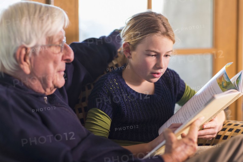 Caucasian grandfather and granddaughter reading