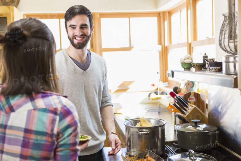 Hispanic couple cooking in kitchen
