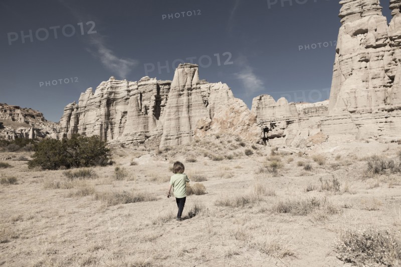 Caucasian preschooler boy walking in desert