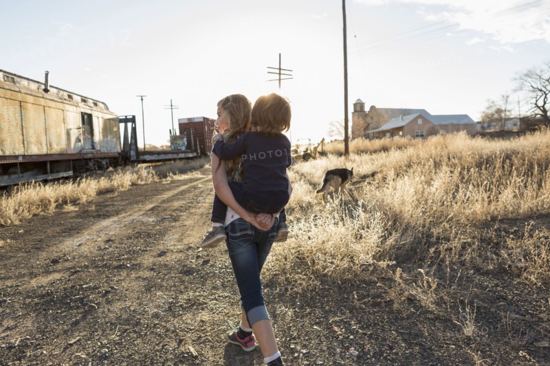 Caucasian girl carrying brother piggyback