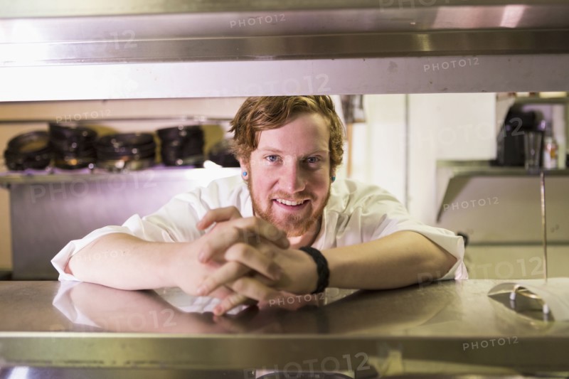 Caucasian chef smiling in restaurant kitchen