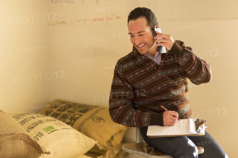 Hispanic entrepreneur talking on telephone in store
