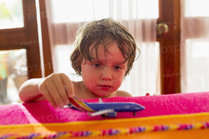 Caucasian boy playing with toy airplane