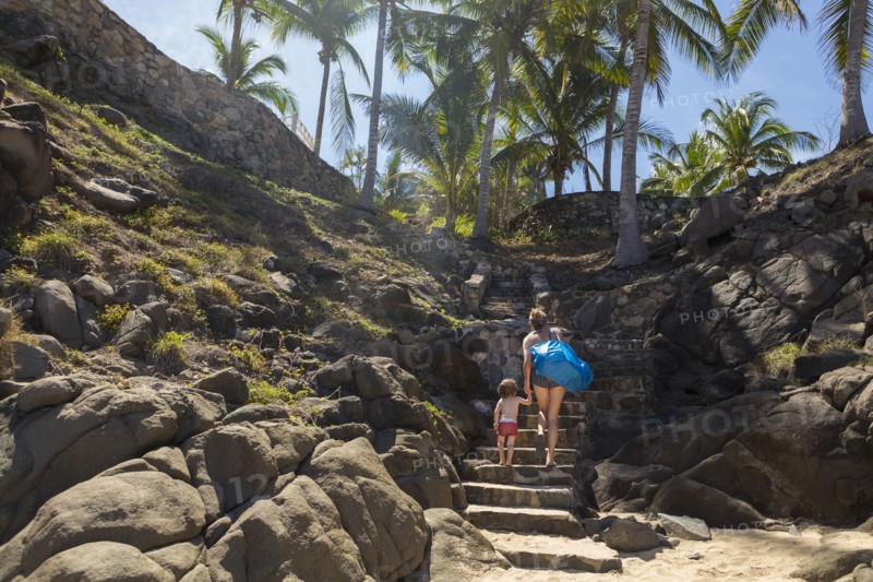 Caucasian mother and son climbing staircase on beach