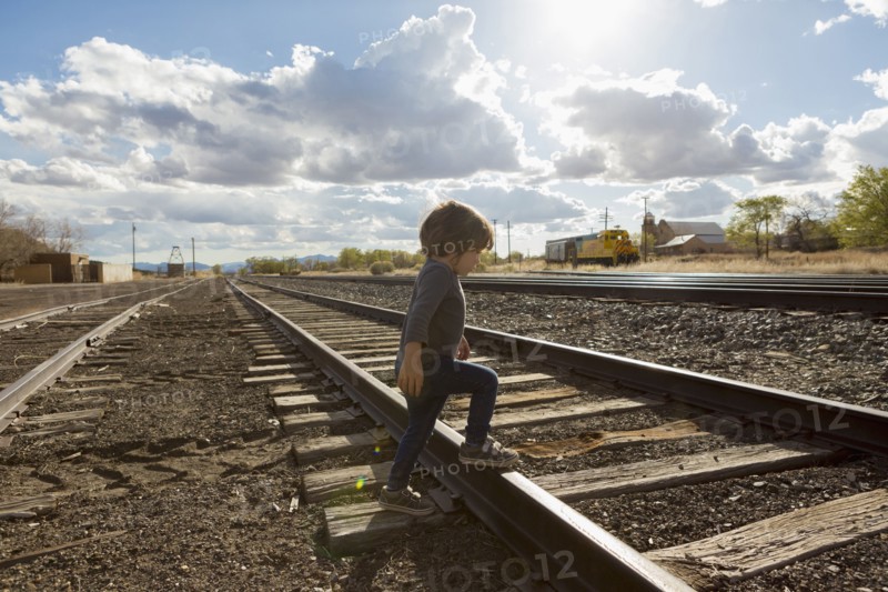 Caucasian boy crossing railroad tracks