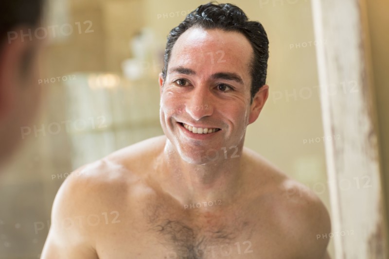 Clean-shaven Hispanic man smiling in mirror