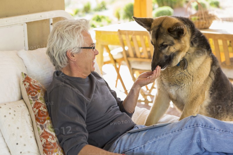 Caucasian man petting dog on patio