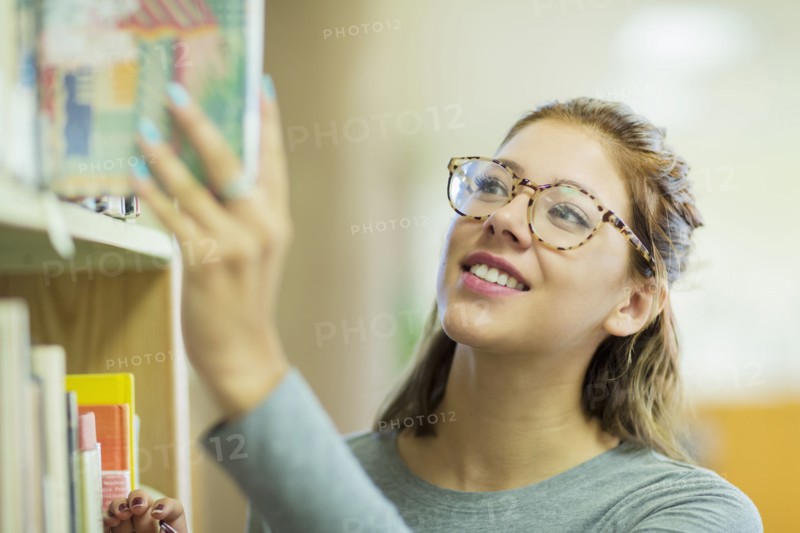 Mixed Race girl choosing book in library