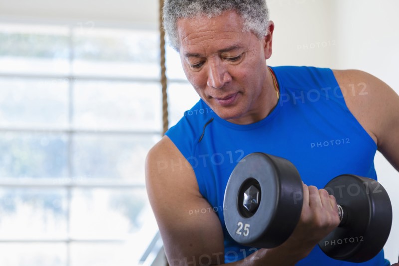 Mixed Race man curling dumbbell
