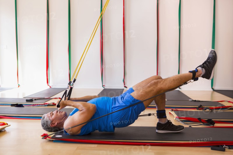 Mixed Race man using resistance bands in gymnasium