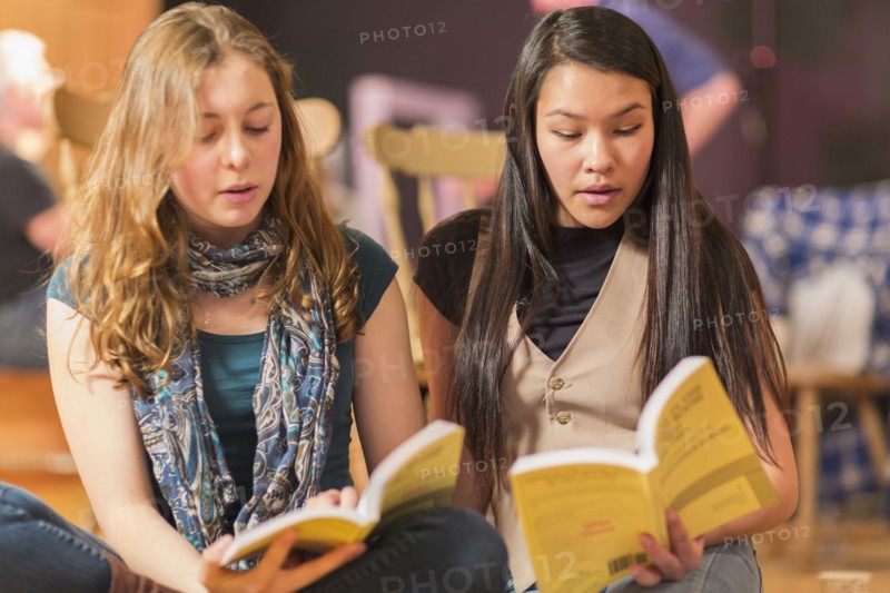 Teenage girls reading scripts in theater class