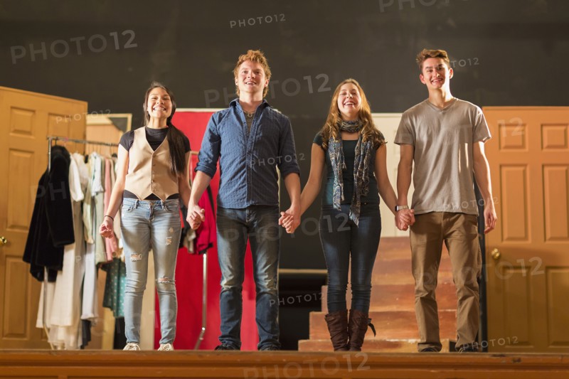 Students holding hands on stage