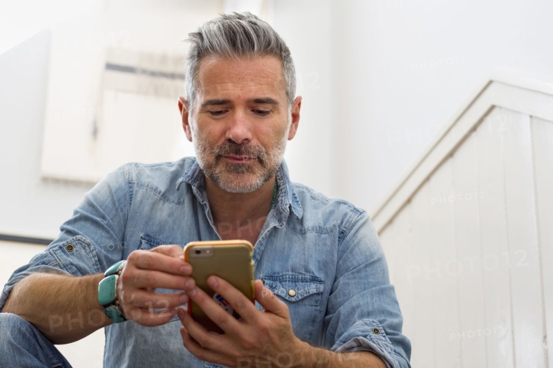 Caucasian man texting on cell phone