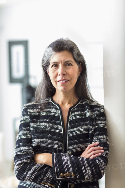 Portrait of Hispanic woman leaning on wall