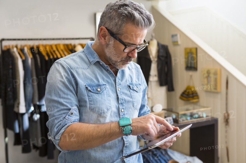 Caucasian man using digital tablet in store
