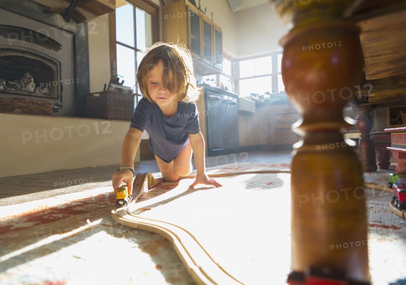Caucasian boy playing with toy race track on floor