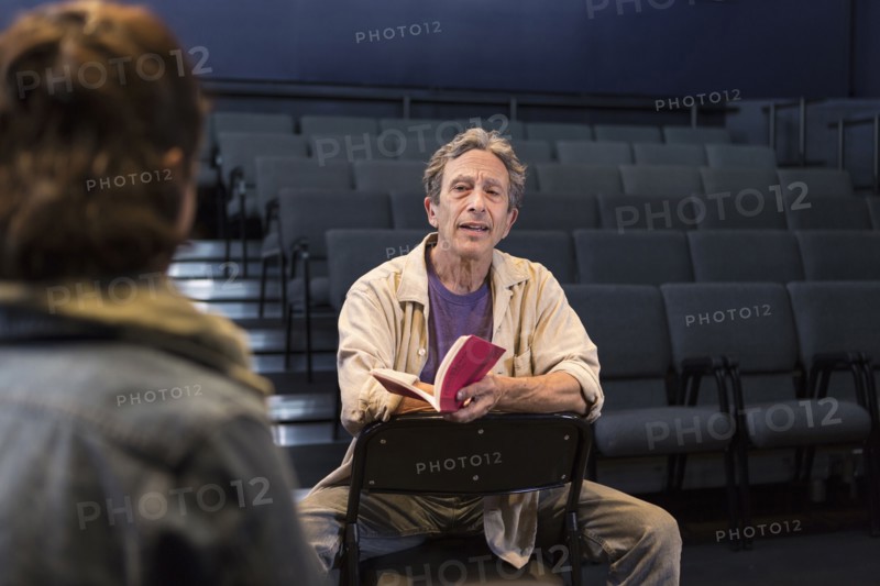 Caucasian actors rehearsing with script in theater