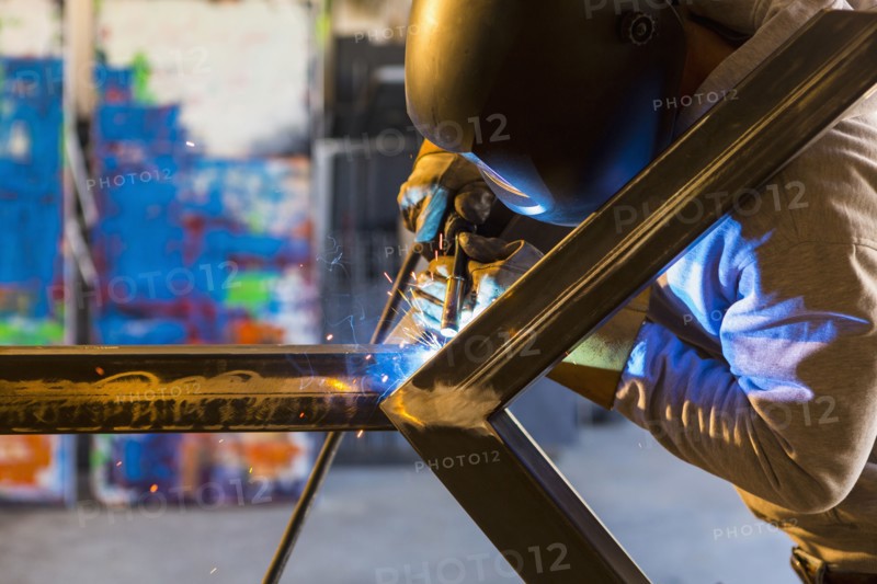 Man welding metal sculpture