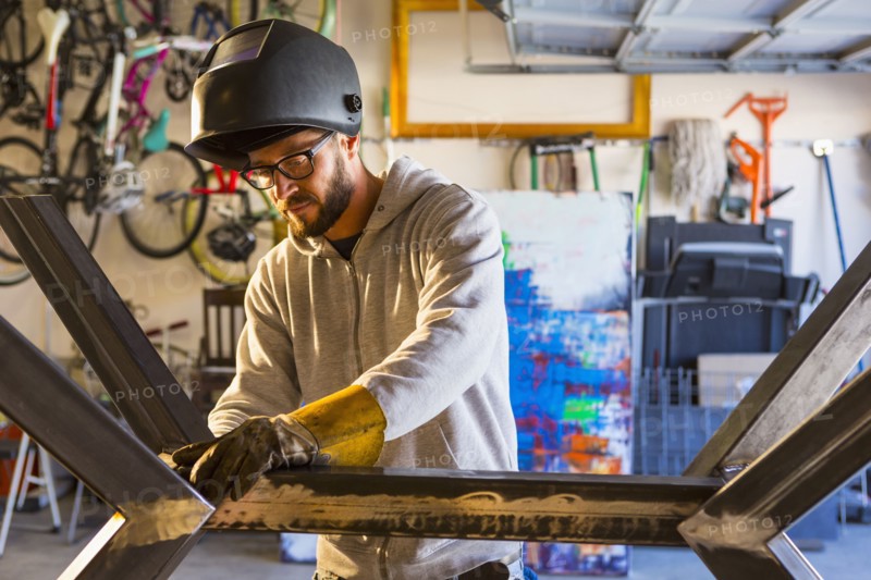 Caucasian man examining metal sculpture