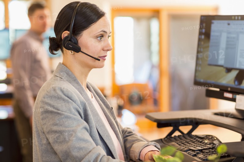Caucasian businesswoman wearing headset using computer