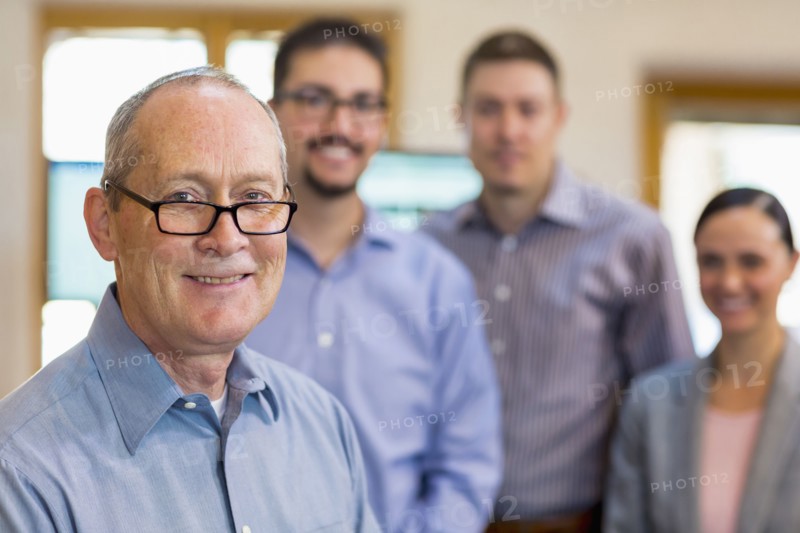 Portrait of smiling businessman and team