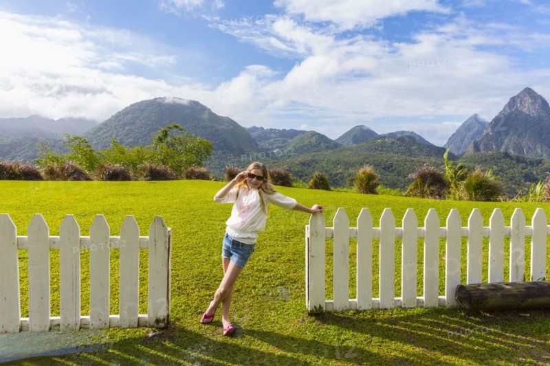 Caucasian girl wearing sunglasses leaning on fence